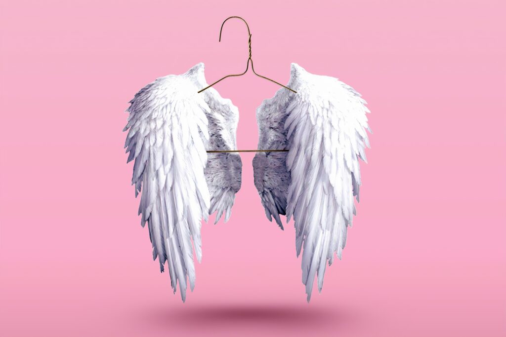 angel wings on a coathanger. Pink background