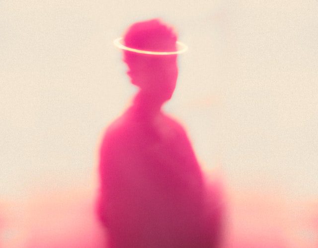 pink person silhouette with a gold halo